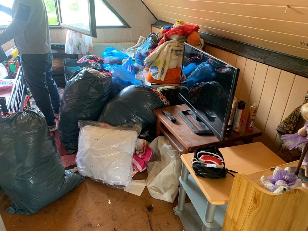 Pièce encombrée de sacs et d'objets lors du vidage d'une maison avant travaux