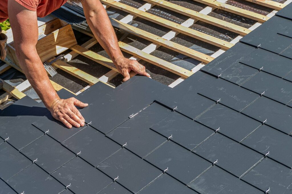 Pose d'ardoises naturelles sur une toiture en rénovation